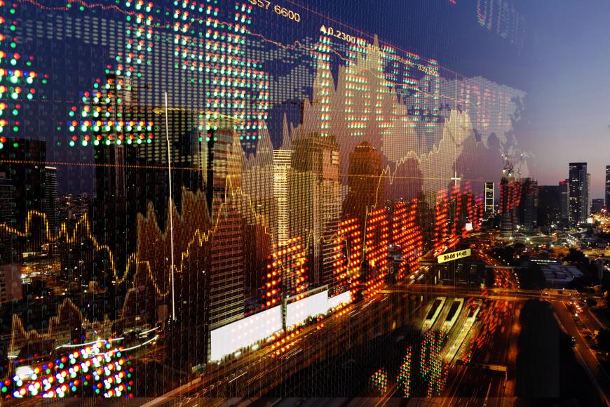 Downward trend of stocks overlaying cityscape